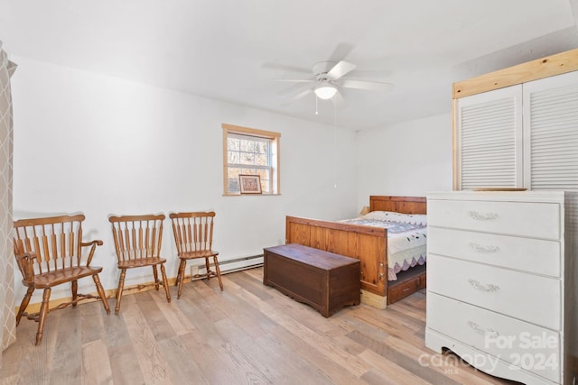 bedroom with light wood-type flooring, baseboard heating, and ceiling fan