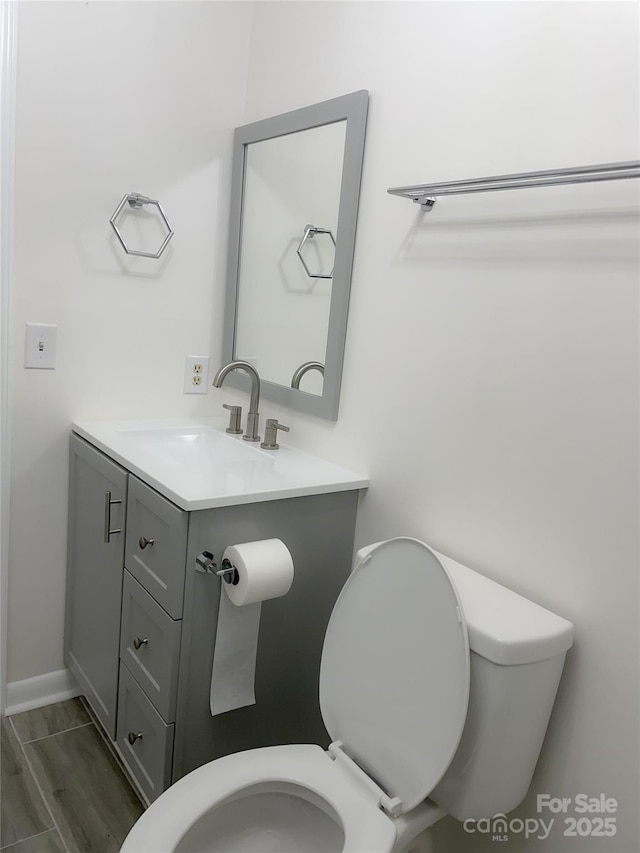 bathroom featuring hardwood / wood-style flooring, vanity, and toilet