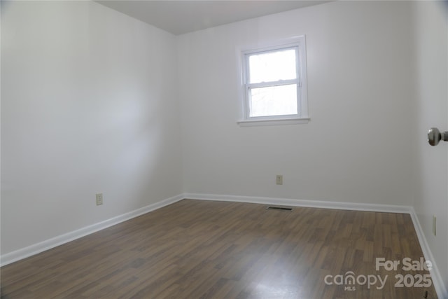 spare room with dark wood-type flooring