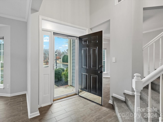 foyer entrance with ornamental molding and hardwood / wood-style flooring