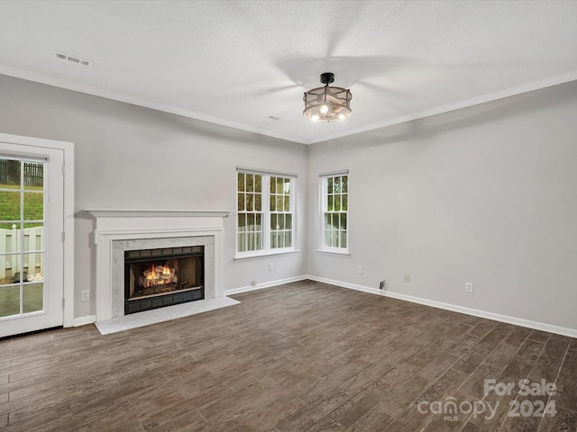 unfurnished living room featuring a textured ceiling, a fireplace, crown molding, and dark wood-type flooring