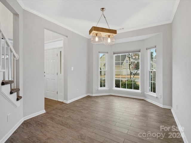 unfurnished dining area featuring crown molding, dark wood-type flooring, and a notable chandelier