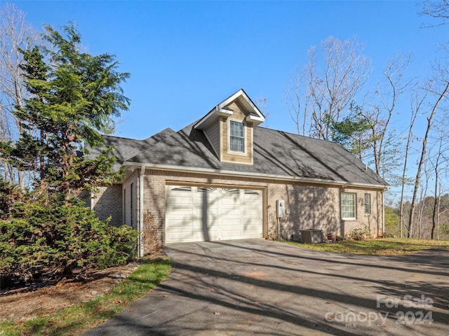 view of front of home with central AC and a garage