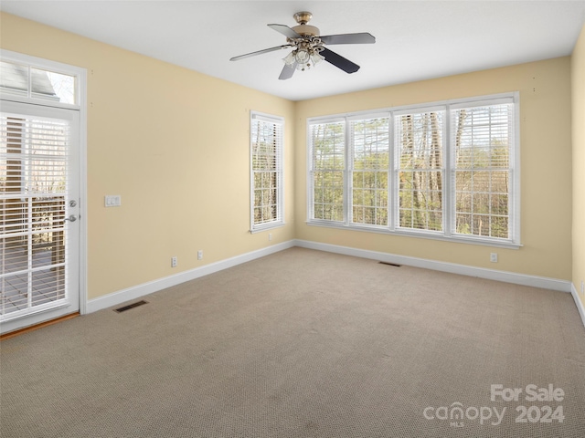 carpeted empty room featuring ceiling fan