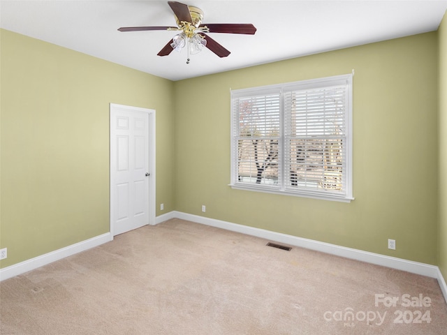 carpeted empty room featuring ceiling fan