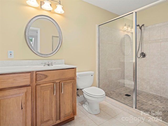 bathroom featuring tile patterned flooring, vanity, an enclosed shower, and toilet