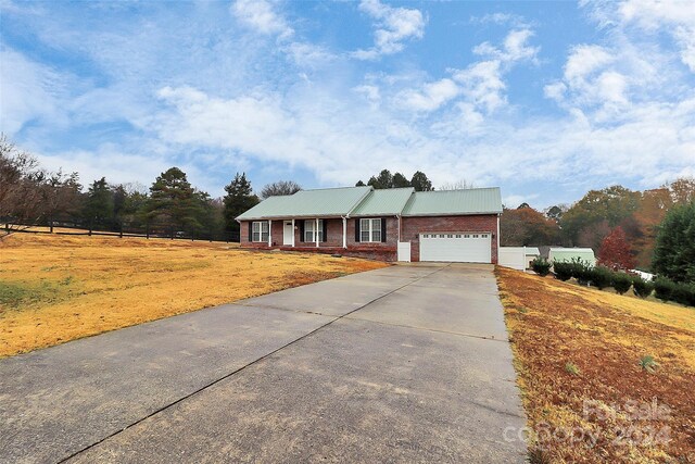 2945 Parks Lafferty Rd, Concord, NC 28025 - ranch-style house with driveway, an attached garage, metal roof, brick siding, and covered porch
