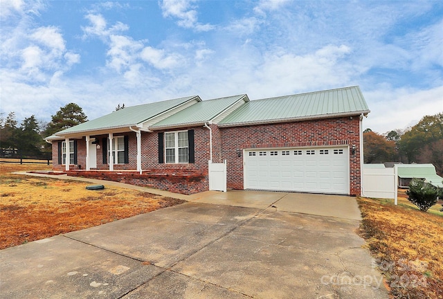2945 Parks Lafferty Rd, Concord, NC 28025 - ranch-style house featuring metal roof, a garage, concrete driveway, and brick siding