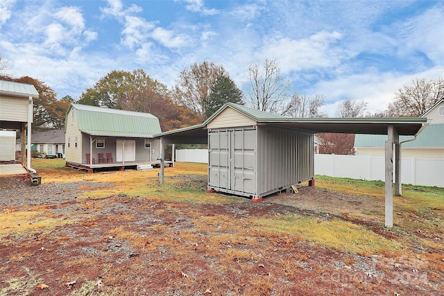 exterior space featuring a carport and an outbuilding