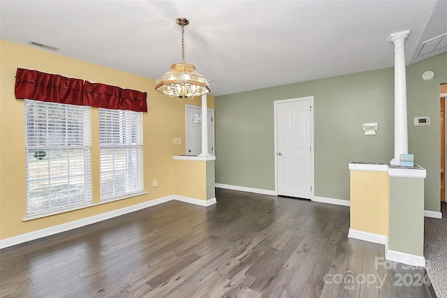 empty room with ornate columns and dark wood-type flooring