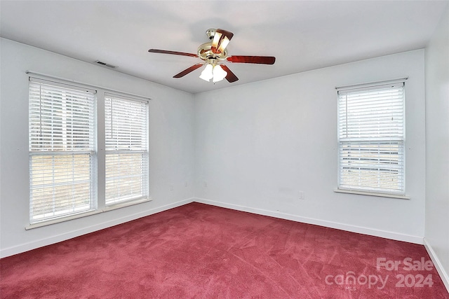 carpeted empty room featuring plenty of natural light and ceiling fan