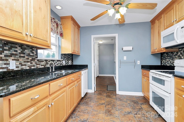 kitchen with decorative backsplash, white appliances, ceiling fan, sink, and dark stone countertops