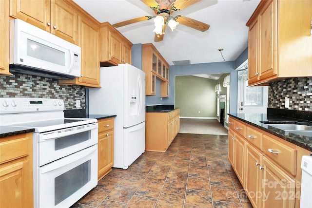 kitchen with backsplash, dark stone counters, white appliances, ceiling fan, and sink