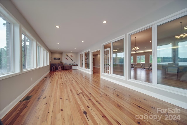 unfurnished sunroom featuring a notable chandelier