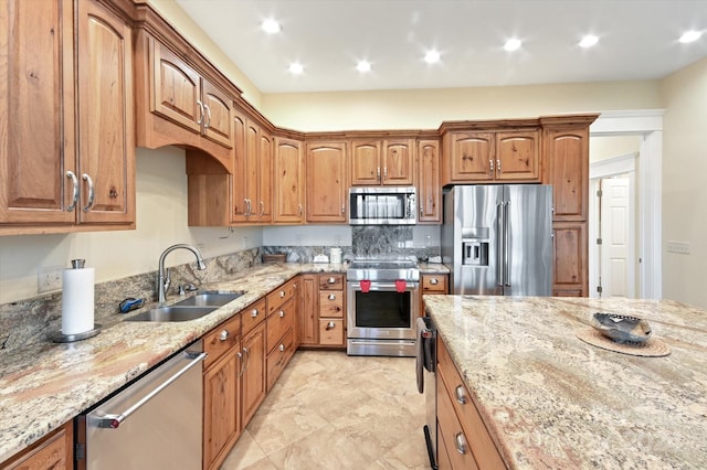 kitchen with light stone countertops, sink, and stainless steel appliances