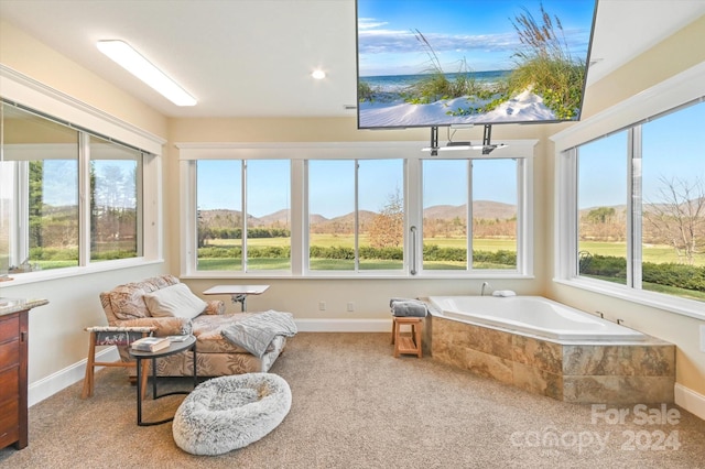 sunroom / solarium featuring a wealth of natural light and a mountain view