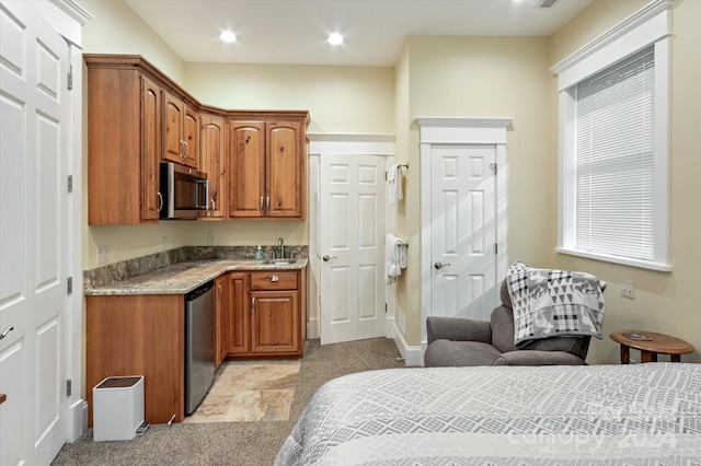 kitchen featuring appliances with stainless steel finishes, light colored carpet, and sink