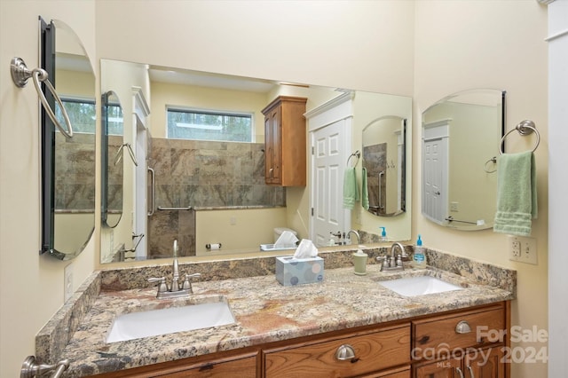 bathroom featuring a tile shower and vanity