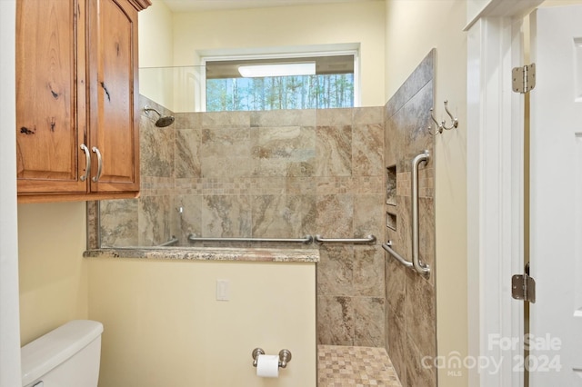 bathroom featuring toilet and tiled shower