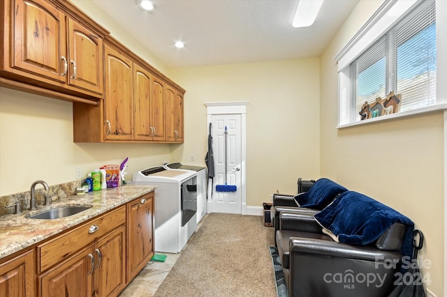 washroom with cabinets, independent washer and dryer, light carpet, and sink