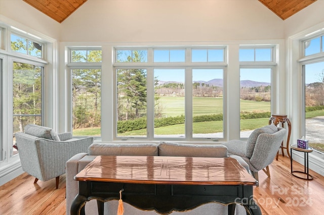 sunroom with wooden ceiling, a wealth of natural light, and vaulted ceiling