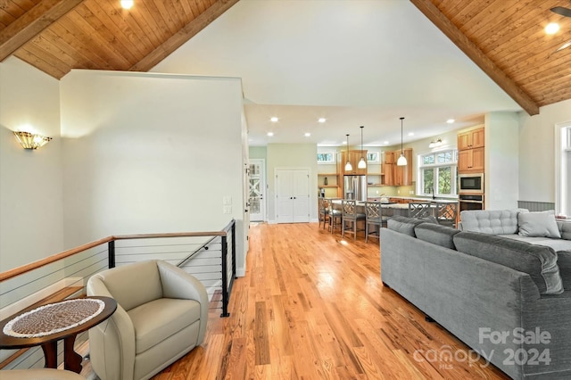 living room with lofted ceiling with beams, light hardwood / wood-style floors, wooden ceiling, and sink