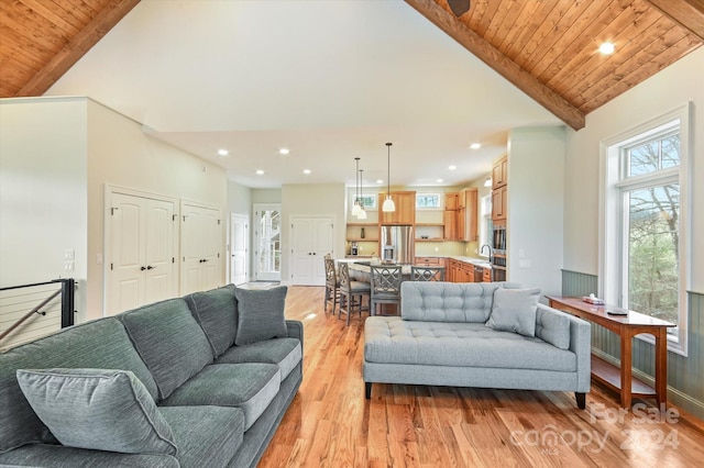 living room featuring light wood-type flooring, wood ceiling, sink, beam ceiling, and high vaulted ceiling