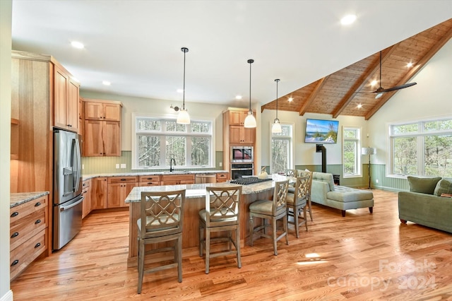 kitchen featuring stainless steel appliances, lofted ceiling with beams, wooden ceiling, light hardwood / wood-style floors, and a kitchen island