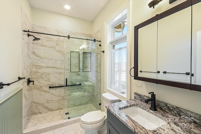 bathroom with vanity, a healthy amount of sunlight, and walk in shower