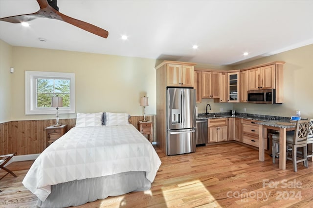 bedroom featuring stainless steel fridge, light hardwood / wood-style flooring, ceiling fan, and sink