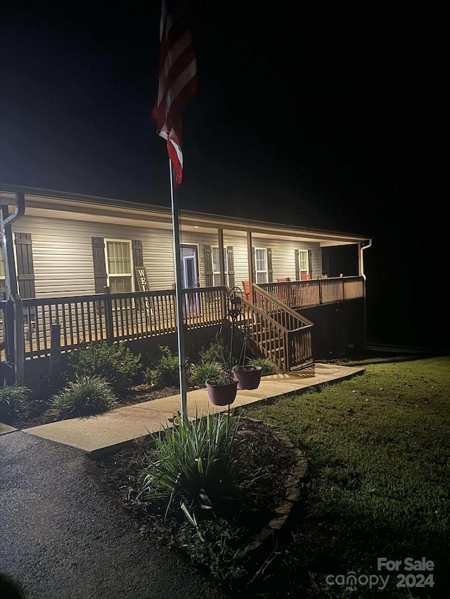 view of front facade featuring a lawn and a deck