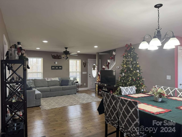 dining room with hardwood / wood-style flooring and ceiling fan with notable chandelier