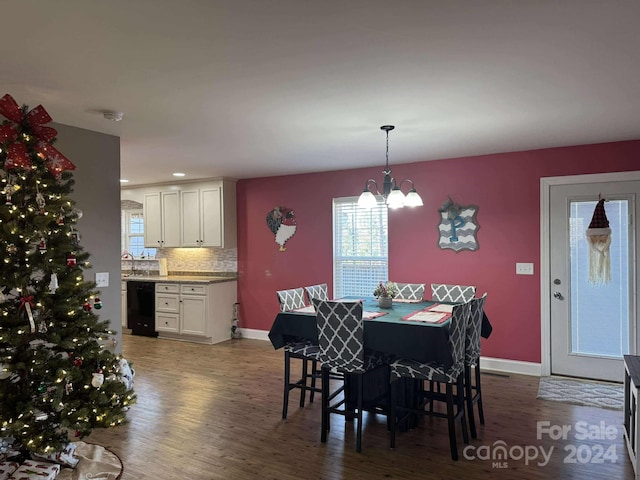 dining area featuring dark hardwood / wood-style floors, sink, and a chandelier