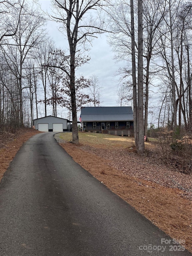 view of front of property featuring an outbuilding, metal roof, and a garage