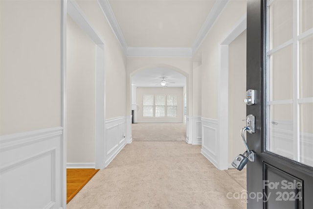 corridor with light tile patterned floors and crown molding