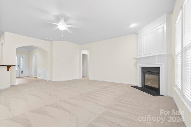 unfurnished living room featuring ceiling fan and light colored carpet