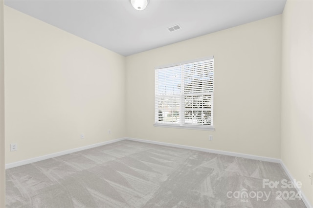 unfurnished room featuring light carpet