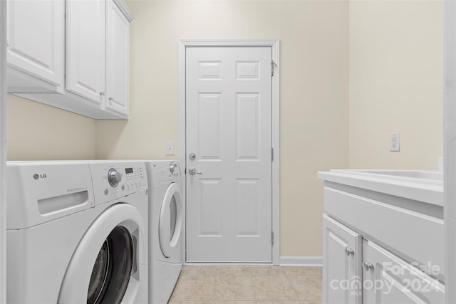 clothes washing area with light tile patterned flooring, cabinets, and washing machine and clothes dryer