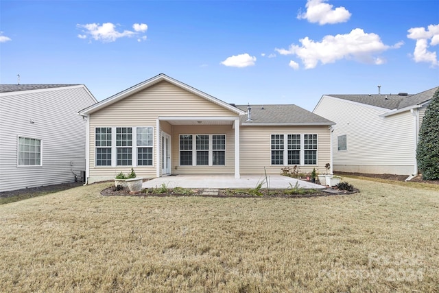 rear view of property featuring a lawn and a patio