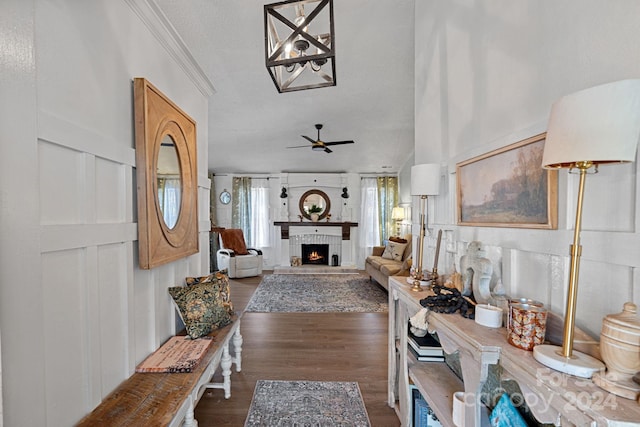 hallway with a textured ceiling, crown molding, and dark hardwood / wood-style floors