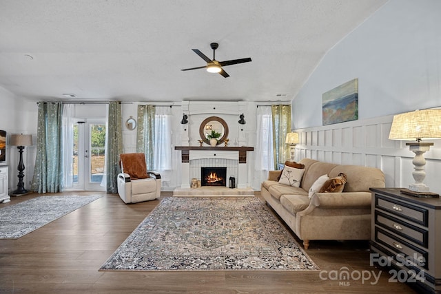 living room featuring ceiling fan, french doors, dark wood-type flooring, lofted ceiling, and a textured ceiling