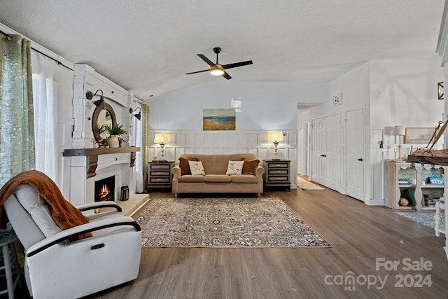 12128 Robins Nest Ln, Charlotte, NC 28269 - living room featuring a ceiling fan, wood finished floors, a fireplace, lofted ceiling, and a textured ceiling