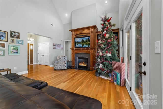 living room featuring wood-type flooring and high vaulted ceiling