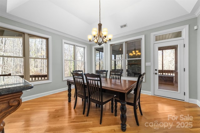 dining room featuring a notable chandelier, ornamental molding, and light wood-type flooring