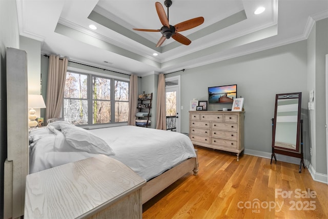 bedroom featuring a raised ceiling, crown molding, ceiling fan, and light hardwood / wood-style floors