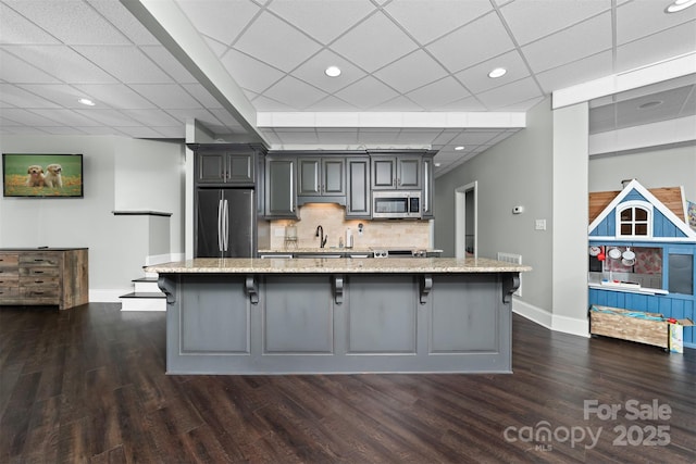 kitchen with an island with sink, appliances with stainless steel finishes, a breakfast bar, and sink