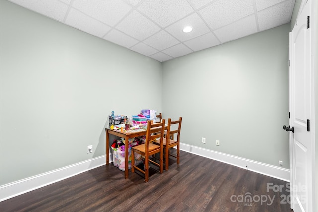 dining room with dark wood-type flooring and a drop ceiling