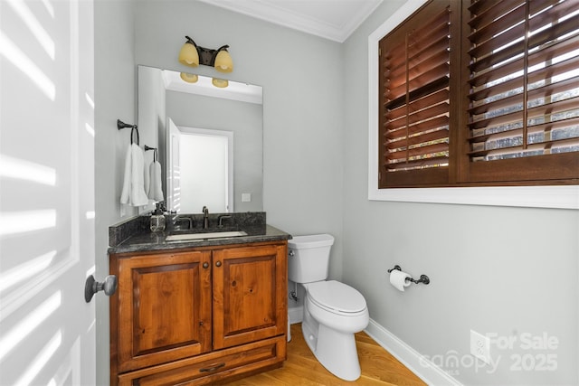 bathroom with hardwood / wood-style flooring, ornamental molding, toilet, and vanity