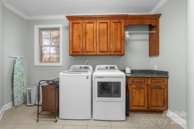 clothes washing area featuring crown molding, cabinets, washing machine and clothes dryer, and light tile patterned flooring