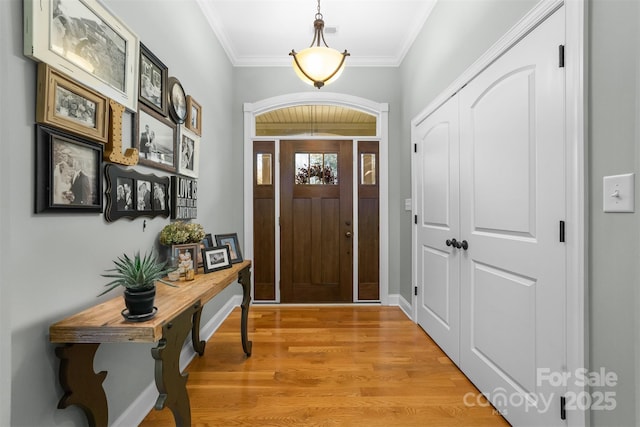 foyer featuring crown molding and light wood-type flooring